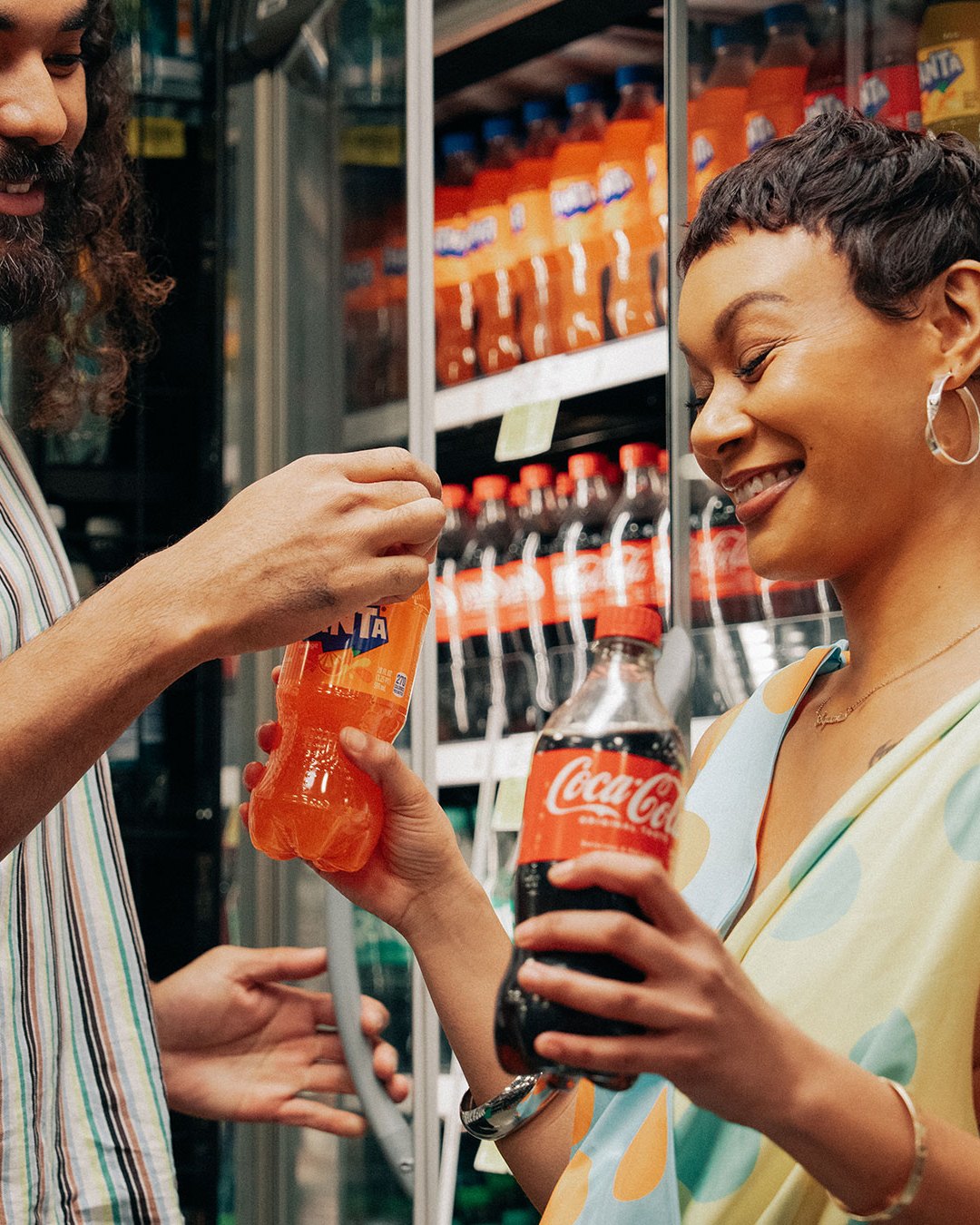 Shoppers choosing Coca-Cola and Fanta from a store chiller